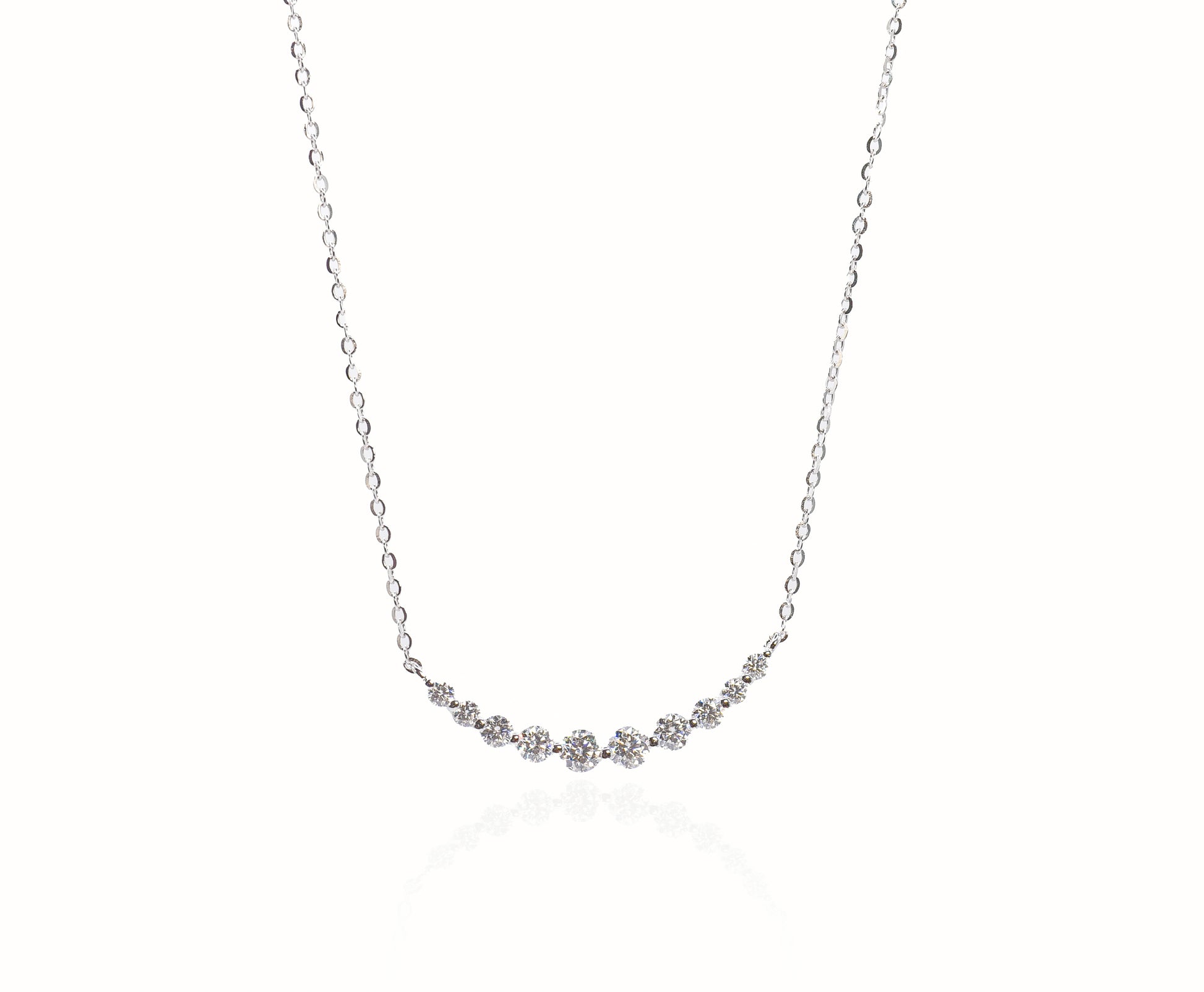 Delicate silver necklace with small gemstones on a white background