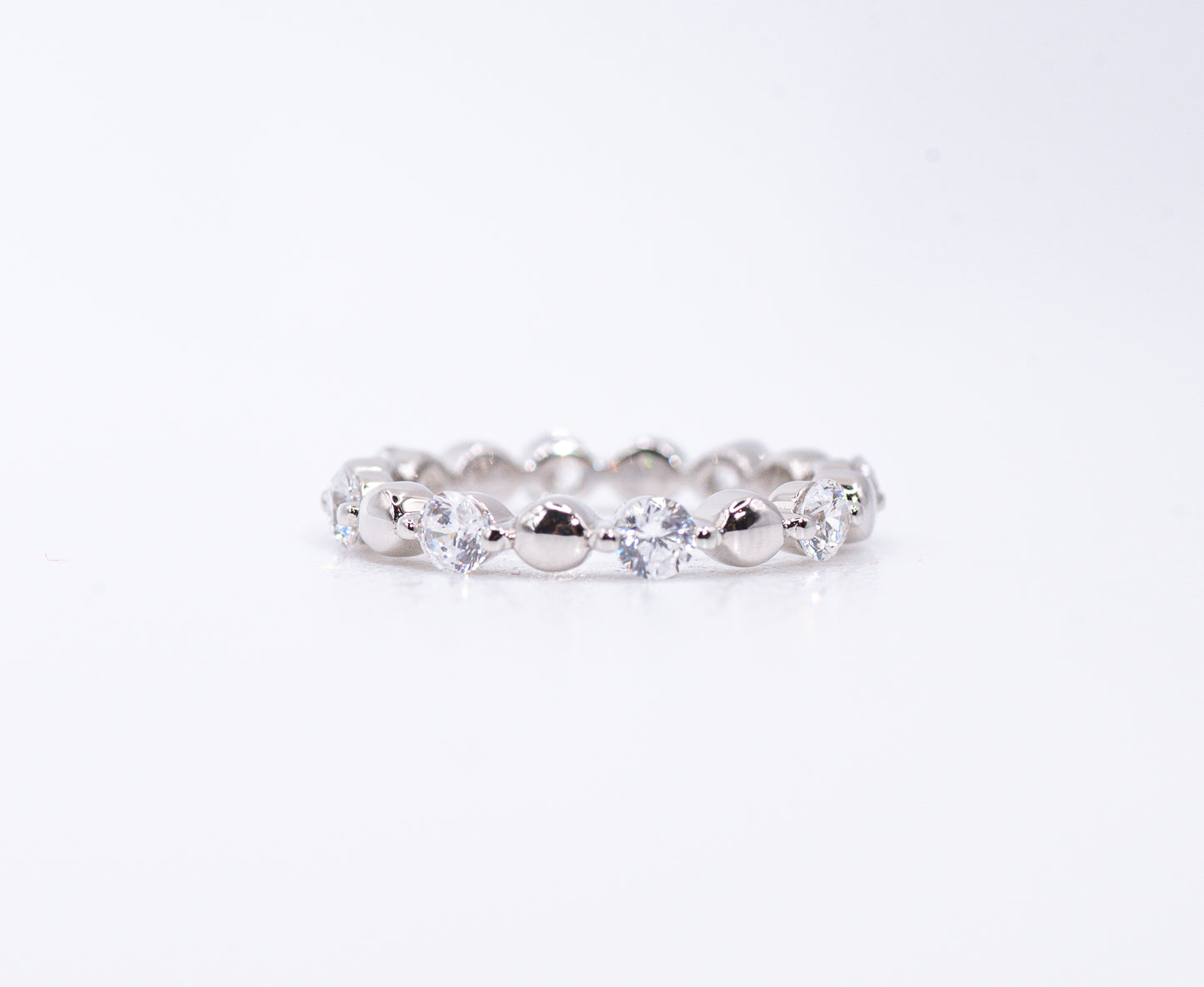 Silver ring with clear gemstones on a white background