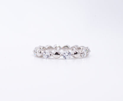 Silver ring with clear gemstones on a white background