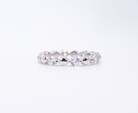 Silver ring with clear gemstones on a white background