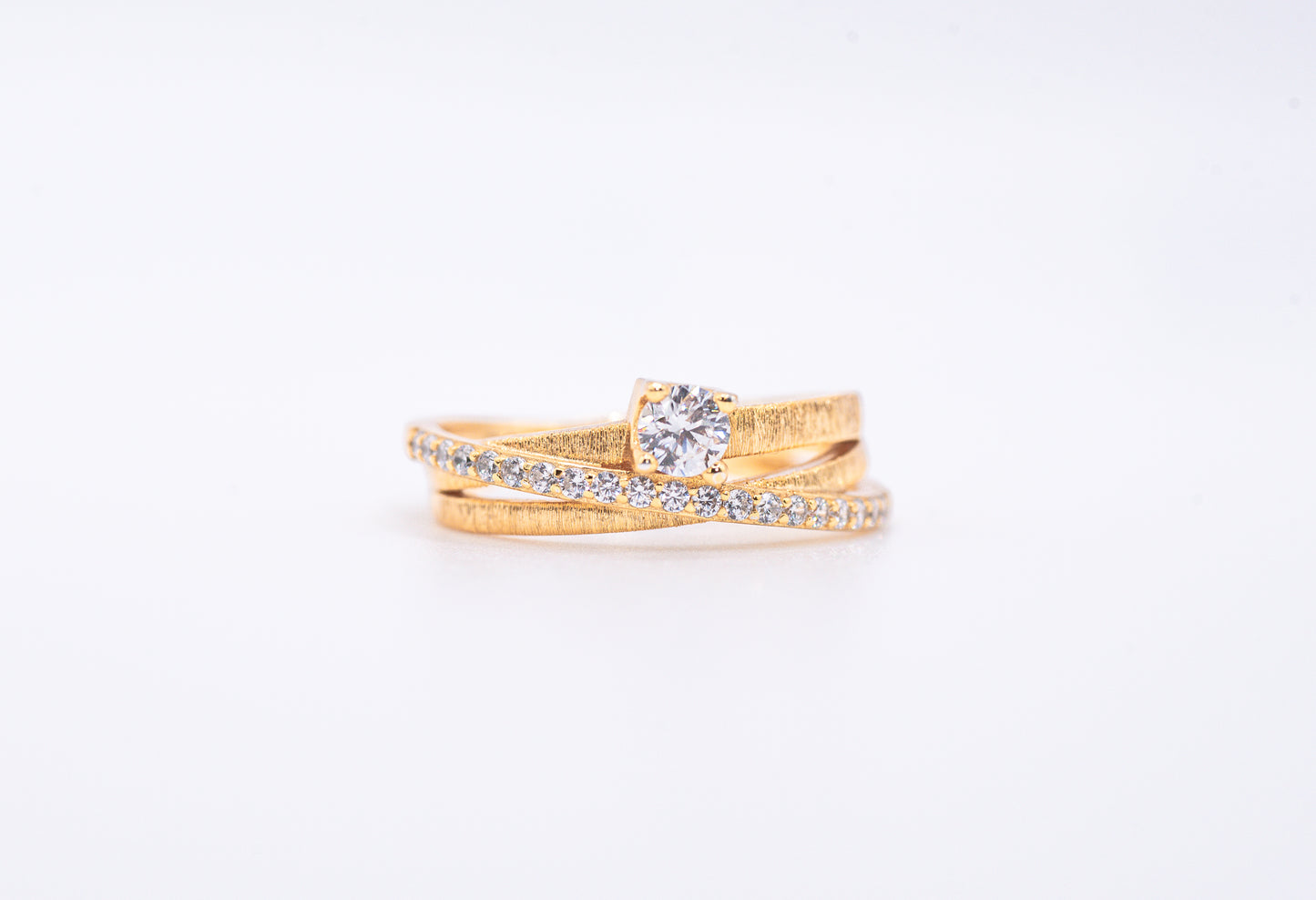 gold color ring with diamond accents on a light gray background