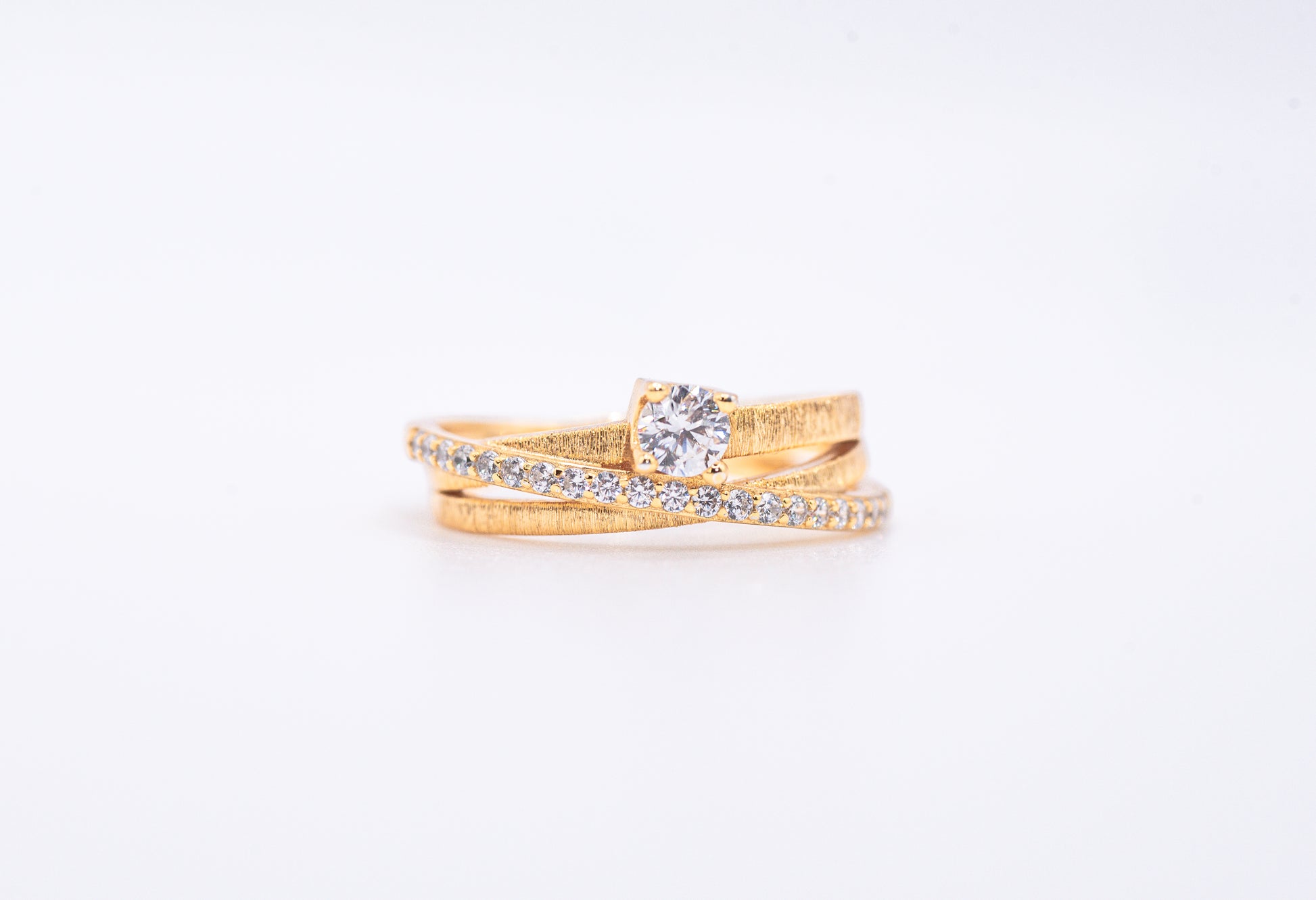 gold color ring with diamond accents on a light gray background