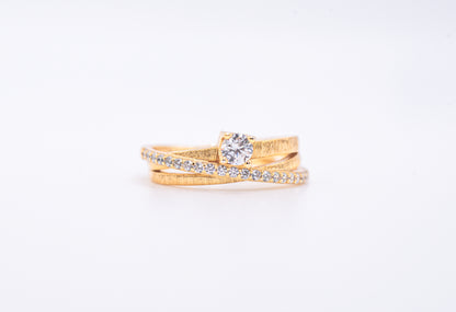 gold color ring with diamond accents on a light gray background
