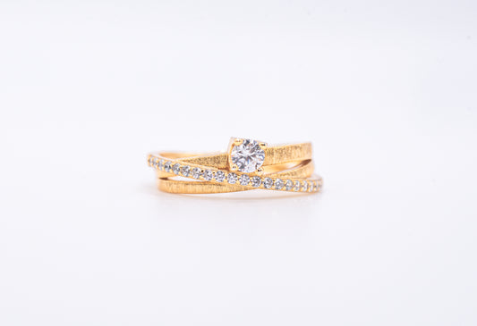 gold color ring with diamond accents on a light gray background