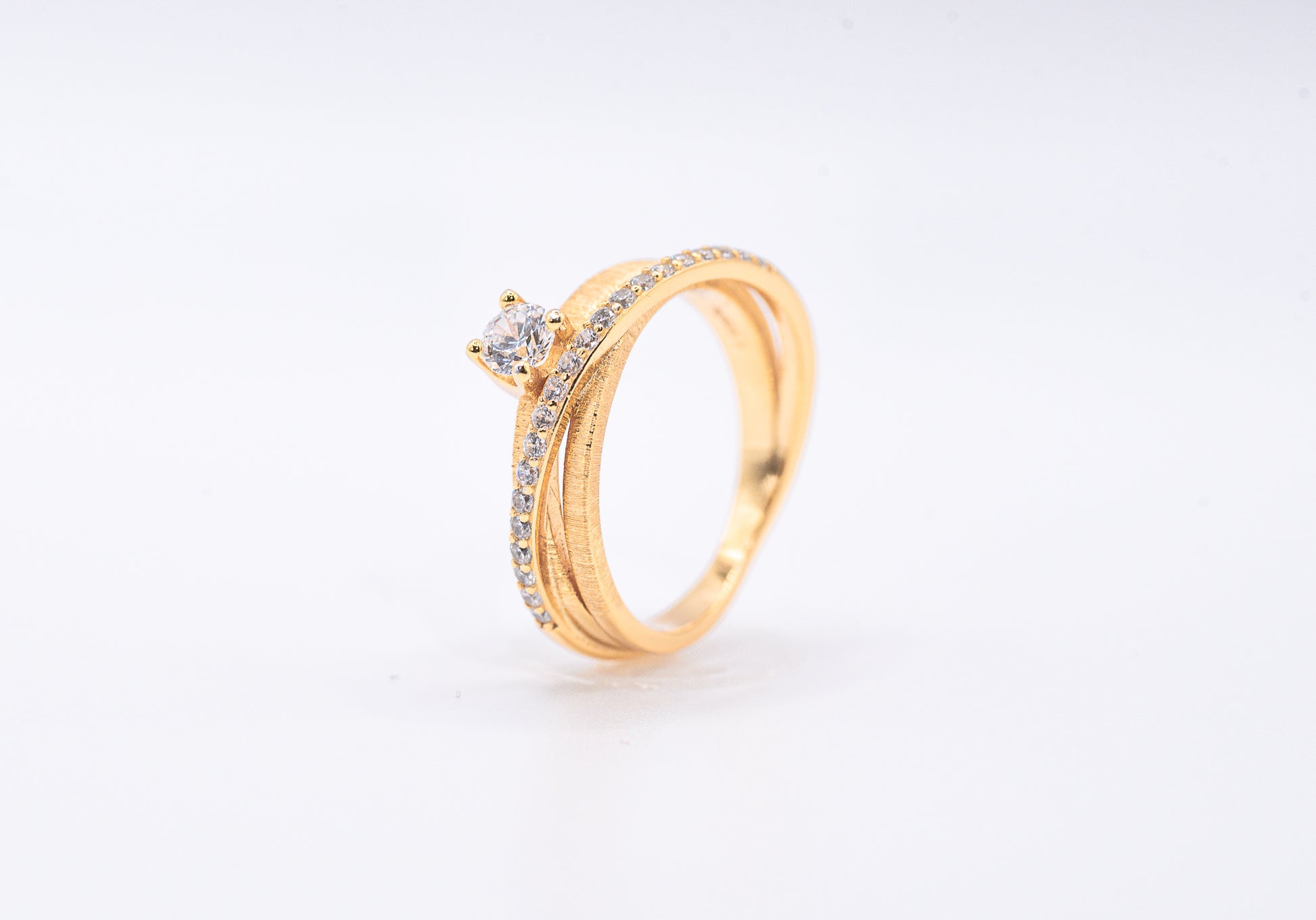 gold color ring with diamond accents on a light gray background
