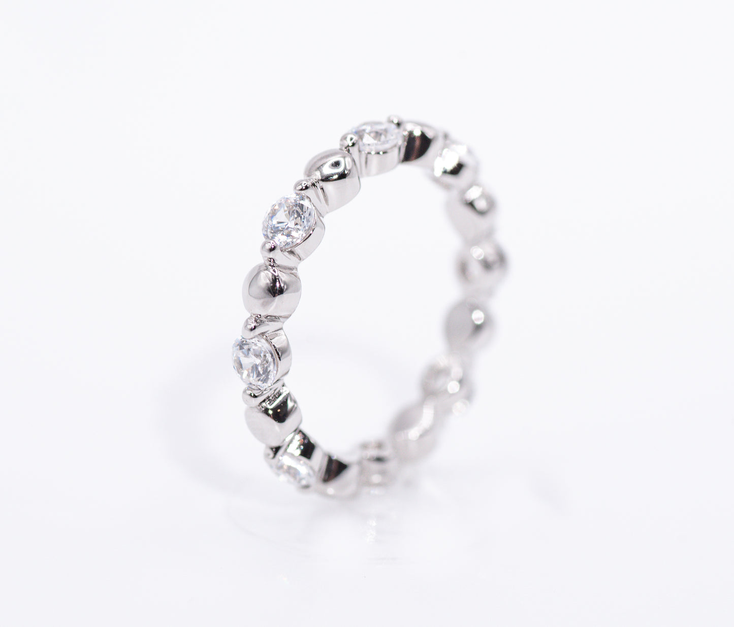 Silver ring with clear gemstones on a white background