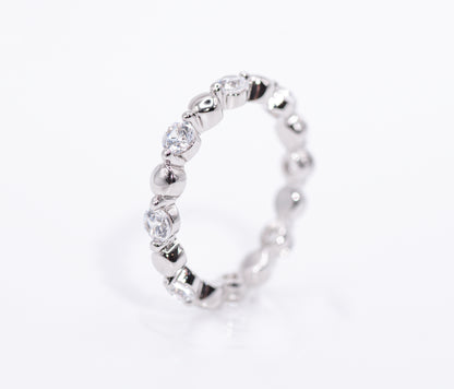 Silver ring with clear gemstones on a white background