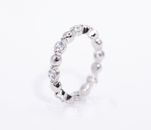 Silver ring with clear gemstones on a white background