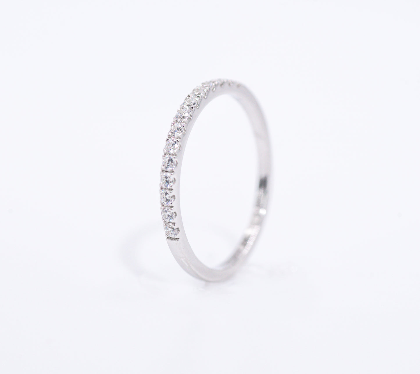 Silver ring with small gemstones on a light gray background