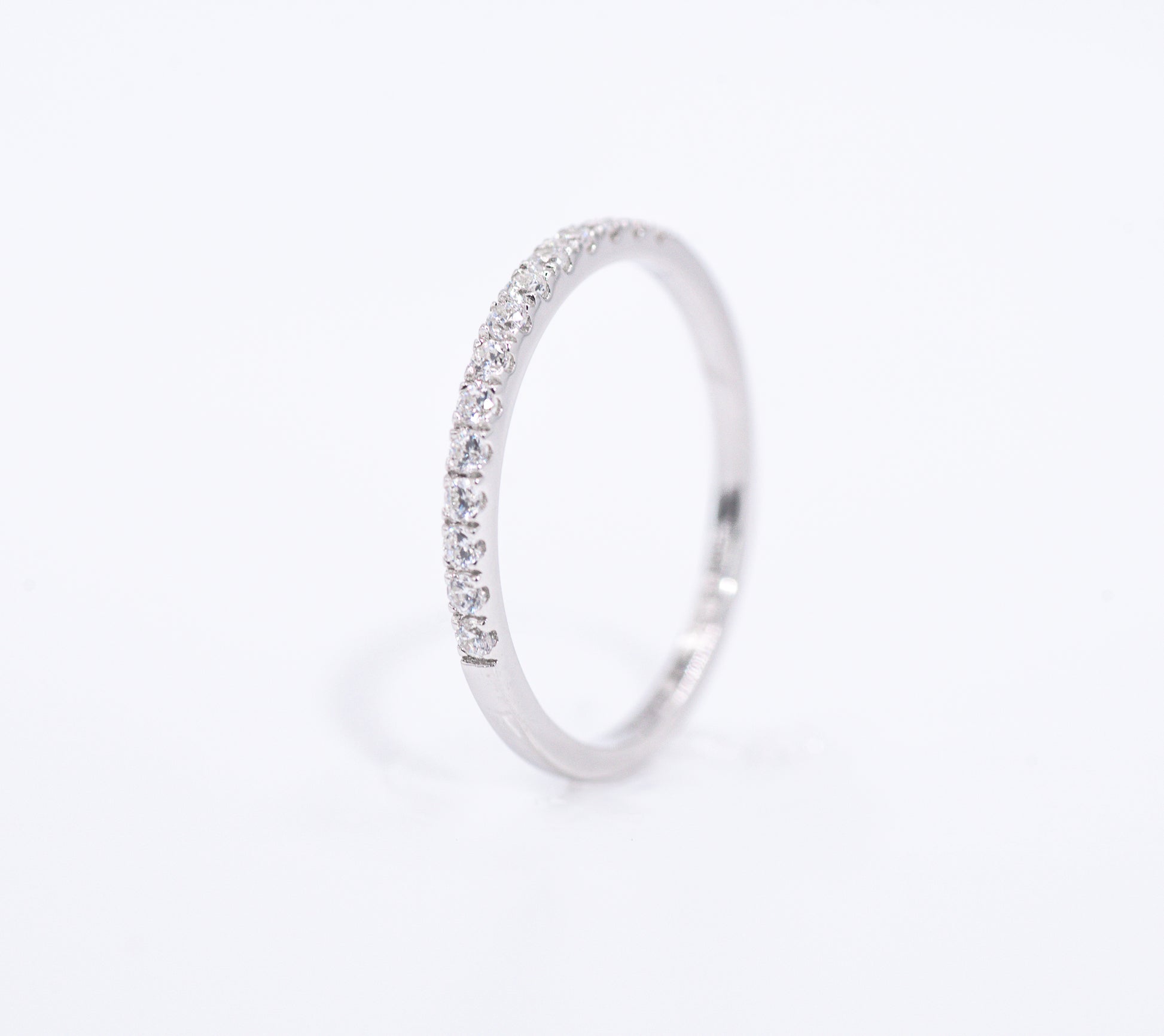 Silver ring with small gemstones on a light gray background