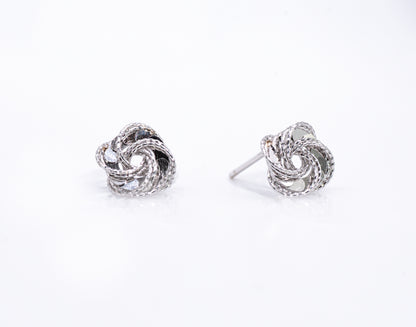 Pair of silver knot earrings on a white background