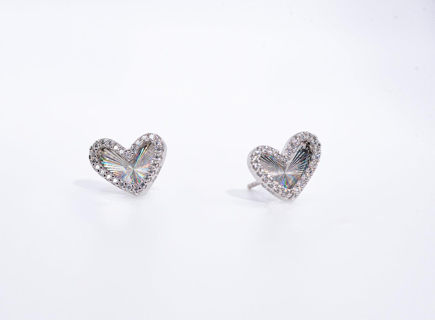 Heart-shaped earrings with clear gemstones on a white background