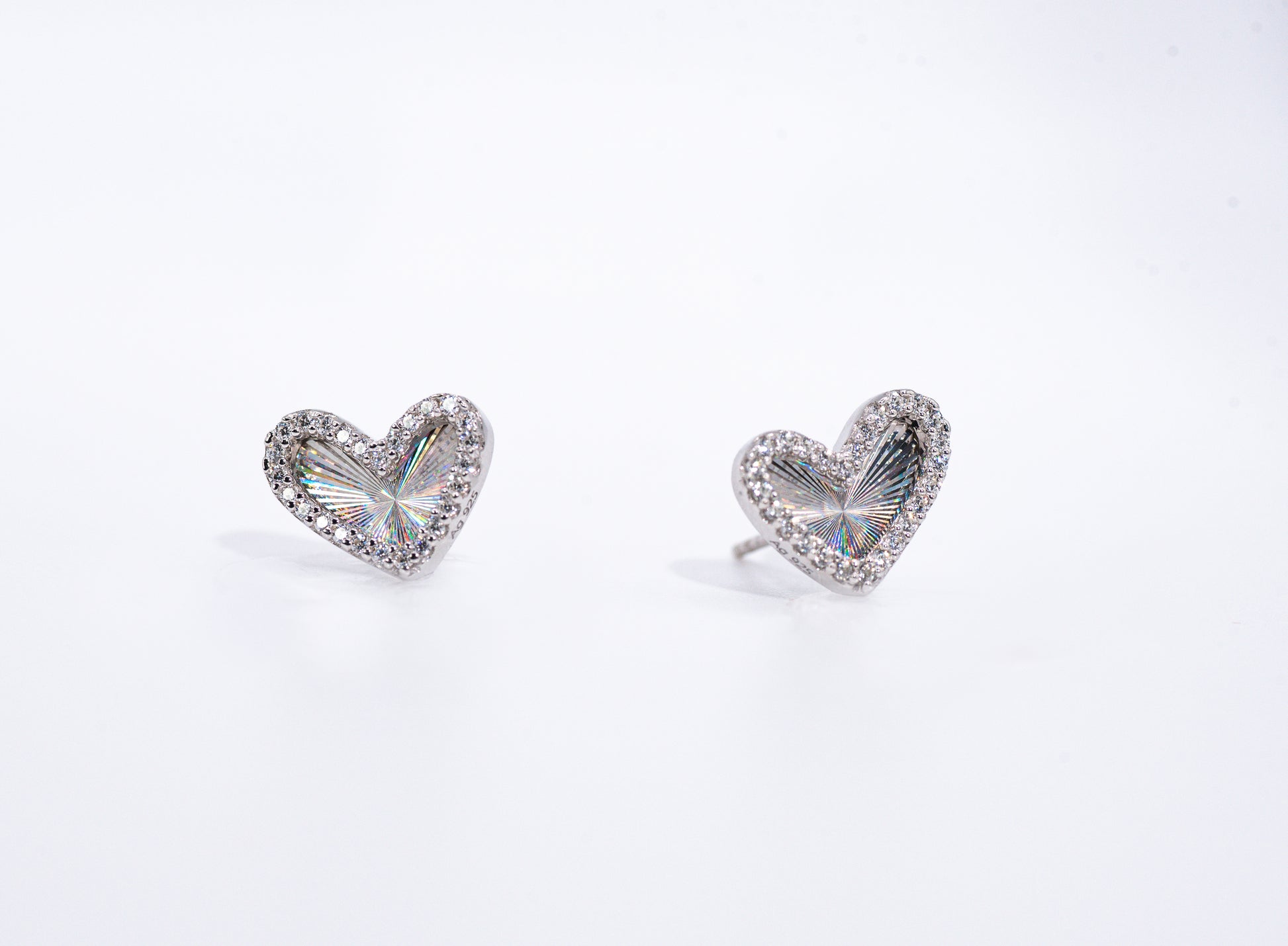 Heart-shaped earrings with clear gemstones on a white background