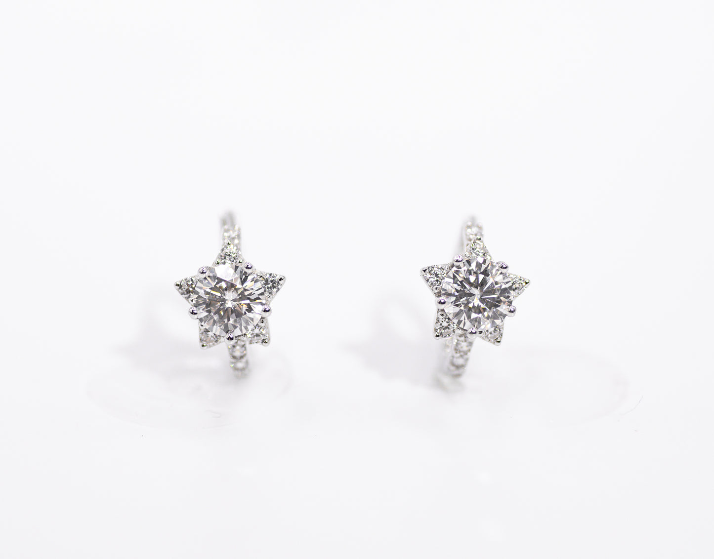 Star-shaped earrings with clear stones on a white background
