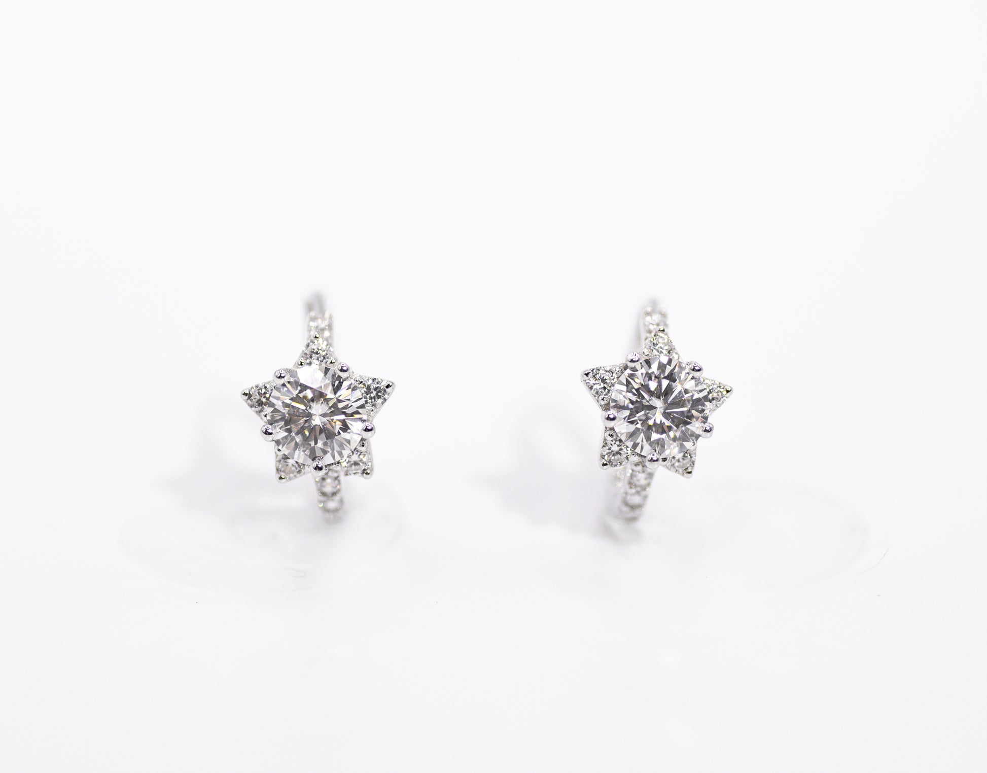 Star-shaped earrings with clear stones on a white background