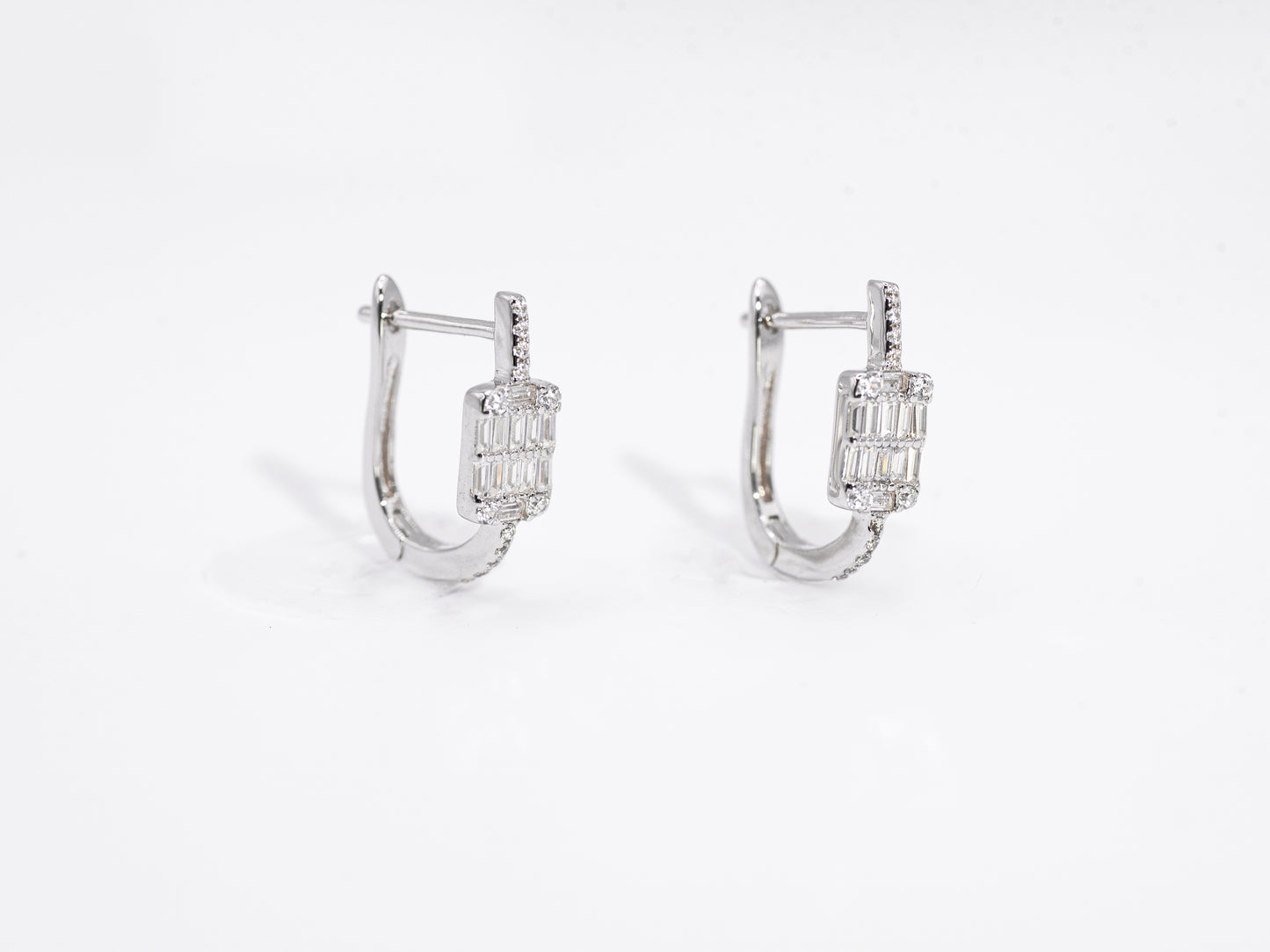 Pair of silver hoop earrings with gemstones on a white background
