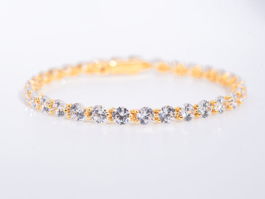 Gold color bracelet with multiple gemstones on a white background