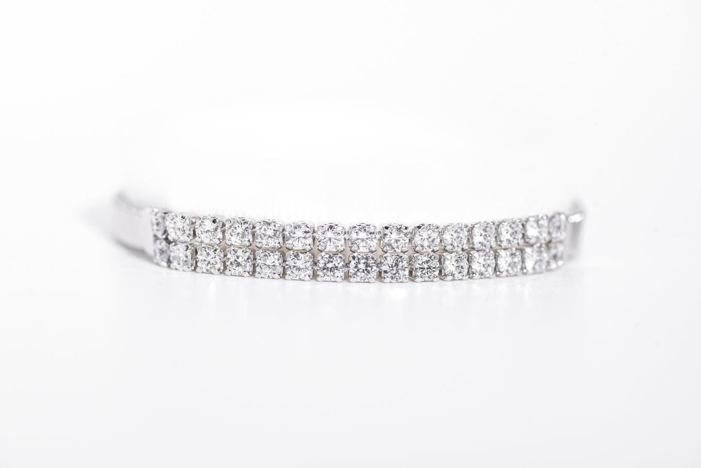 Silver bracelet with clear gemstones on a white background