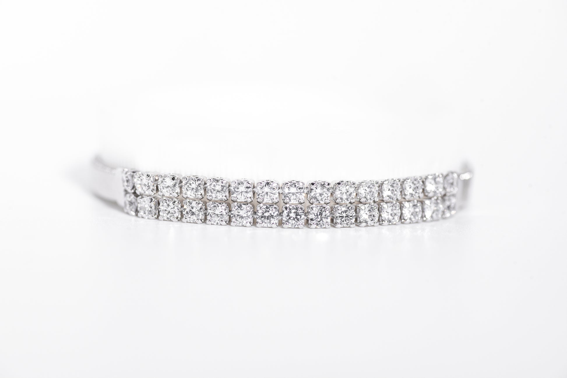 Silver bracelet with clear gemstones on a white background