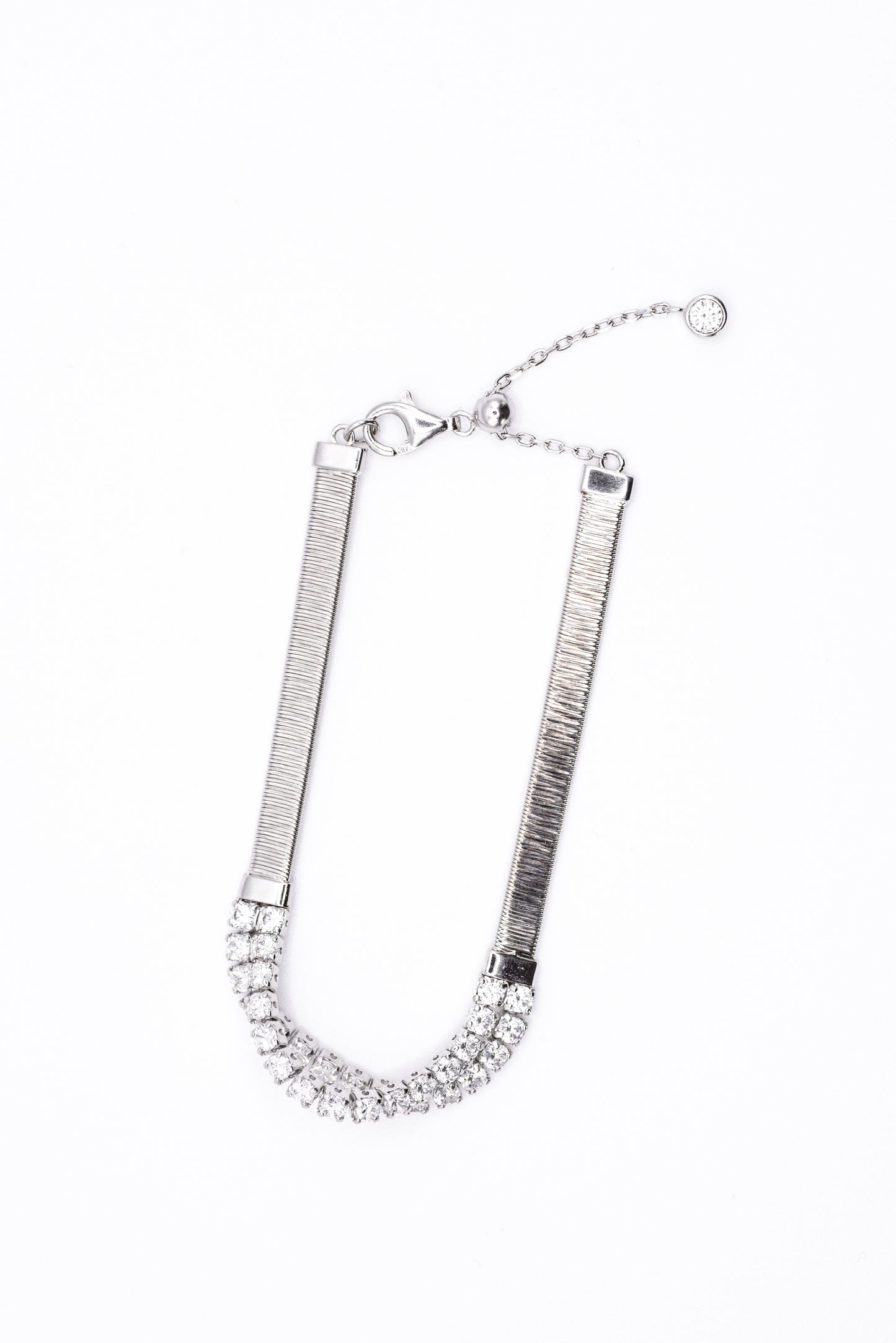 Silver bracelet with clear gemstones on a white background