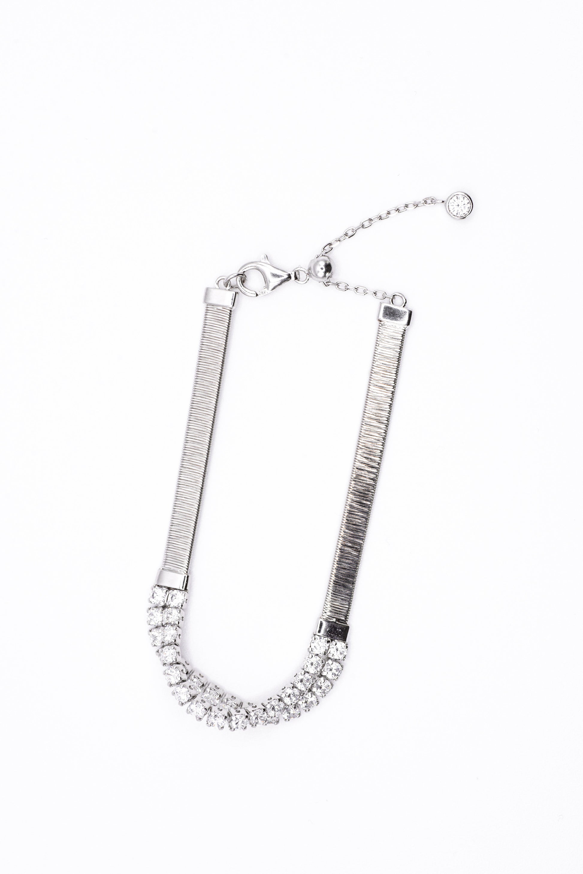 Silver bracelet with clear gemstones on a white background