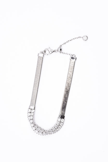 Silver bracelet with clear gemstones on a white background