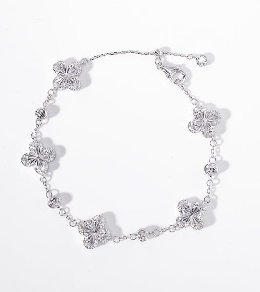 Silver bracelet with floral designs on a white background