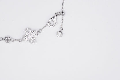 Silver bracelet with floral designs on a white background
