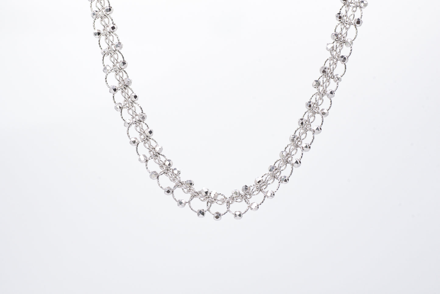 Silver necklace with light gray background