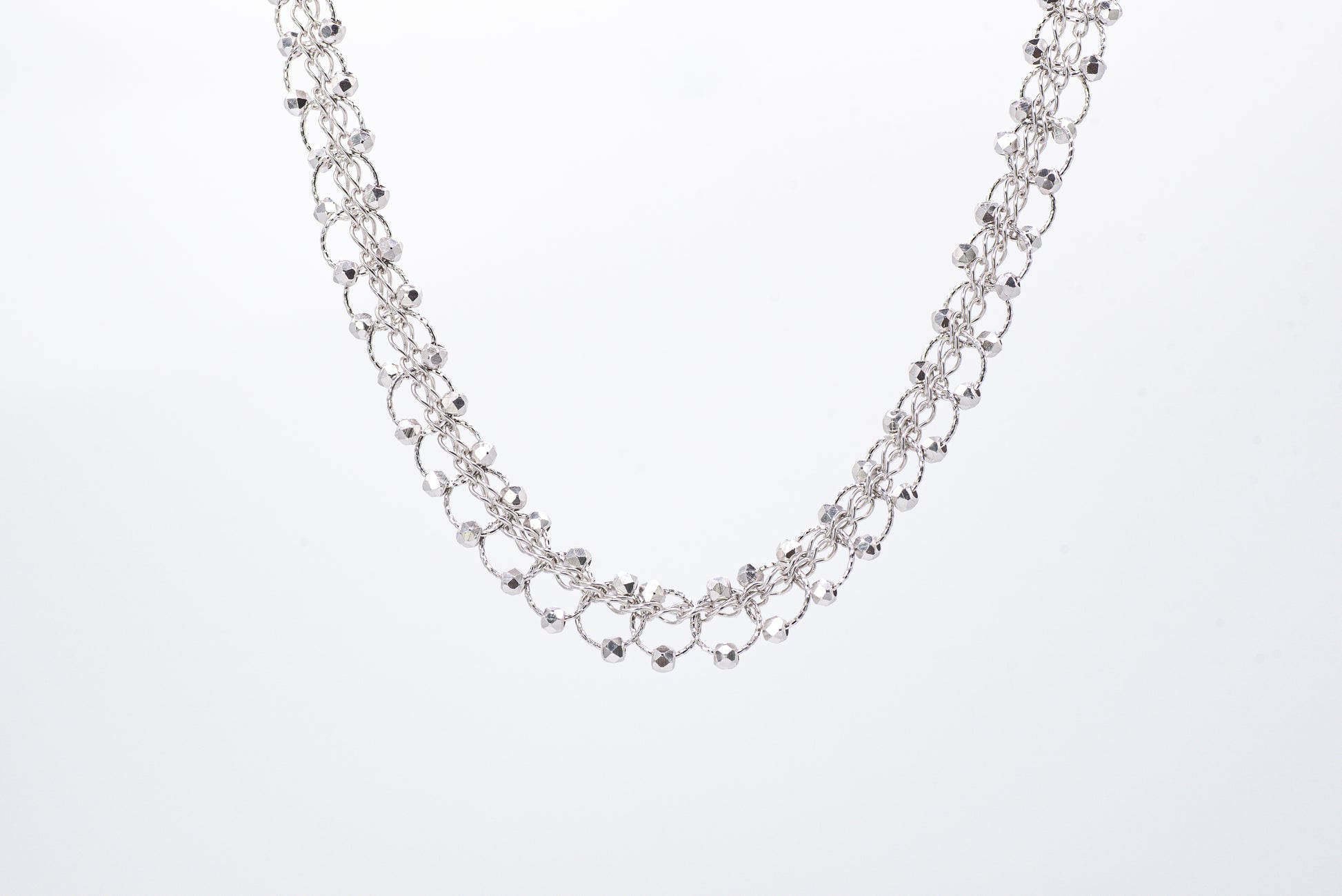 Silver necklace with light gray background