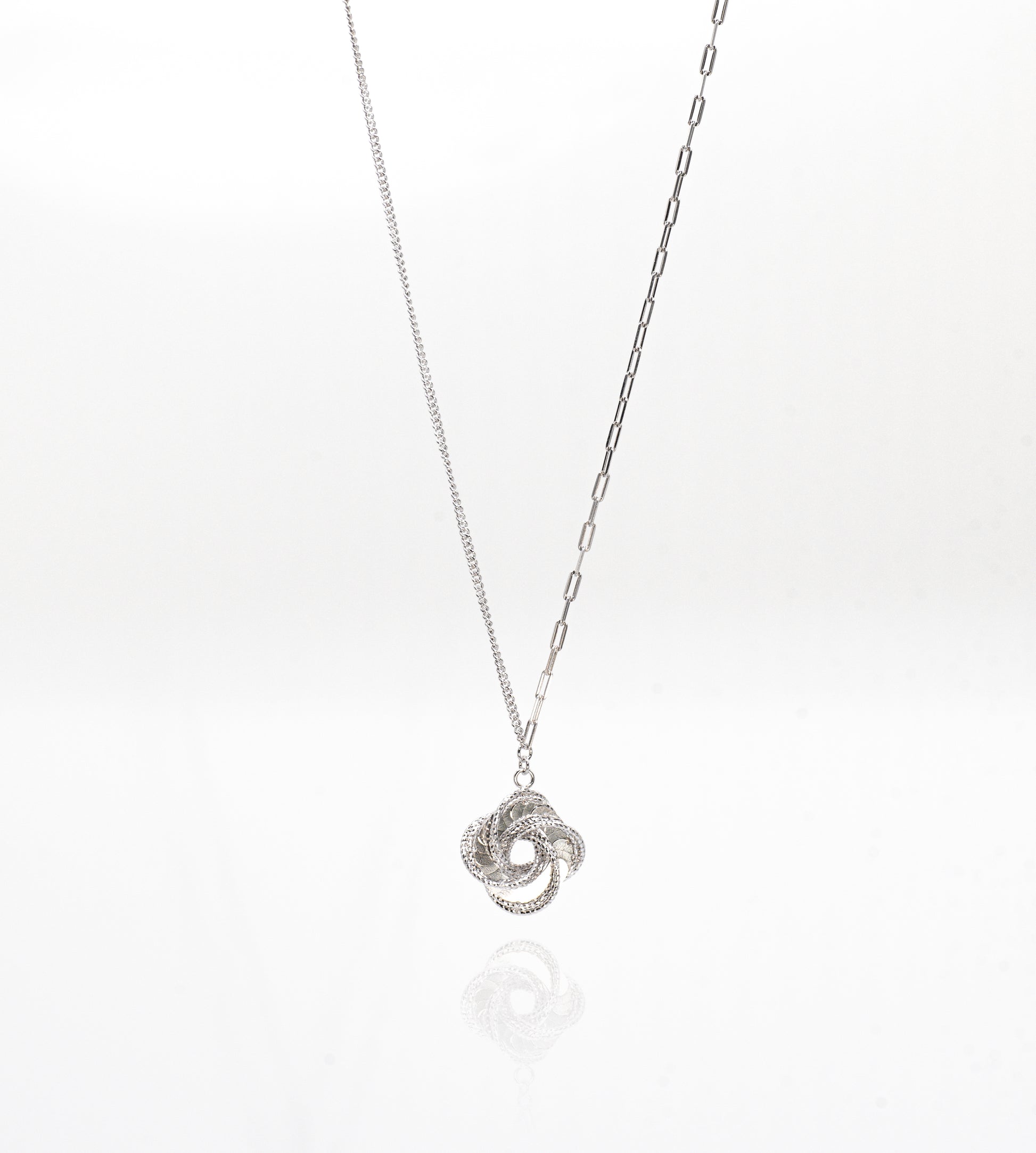 Silver necklace with a intricate pendant on a white background