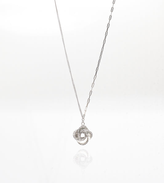 Silver necklace with a intricate pendant on a white background