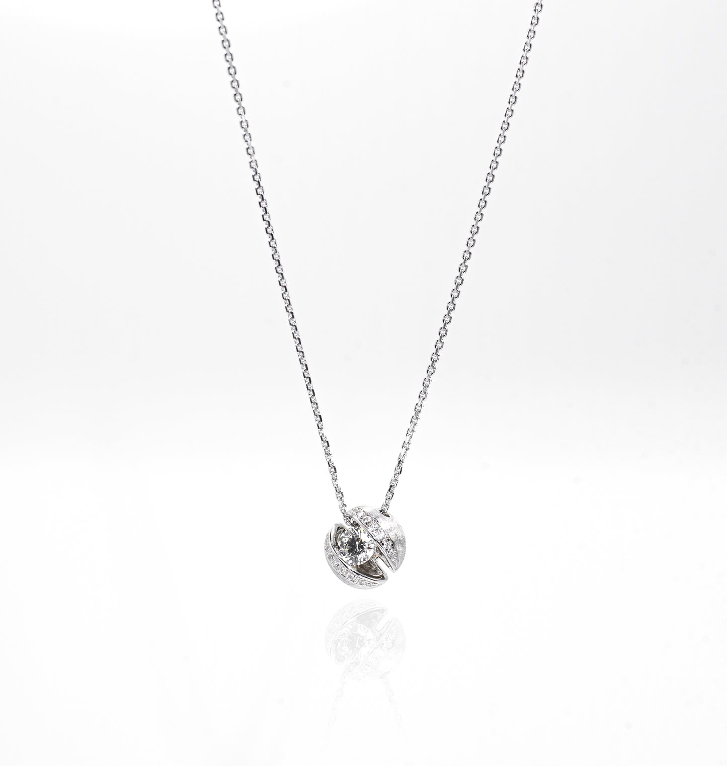 Silver necklace with a small round pendant on a white background