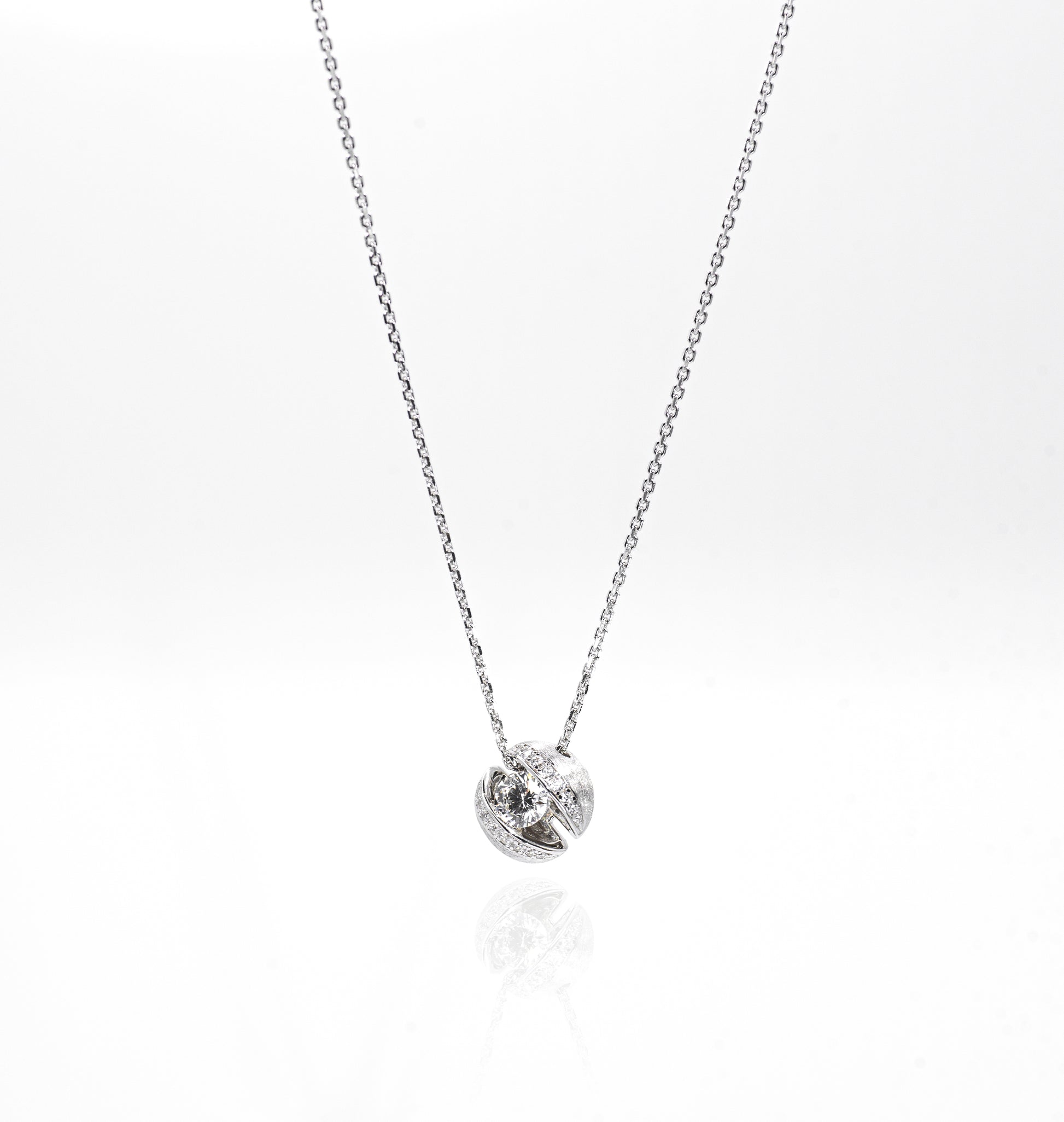 Silver necklace with a small round pendant on a white background