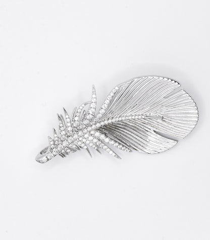 Silver feather-shaped brooch with gemstones on a white background