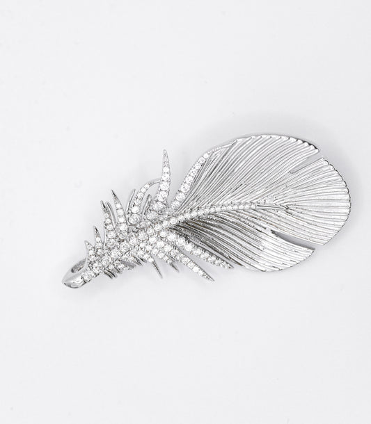 Silver feather-shaped brooch with gemstones on a white background