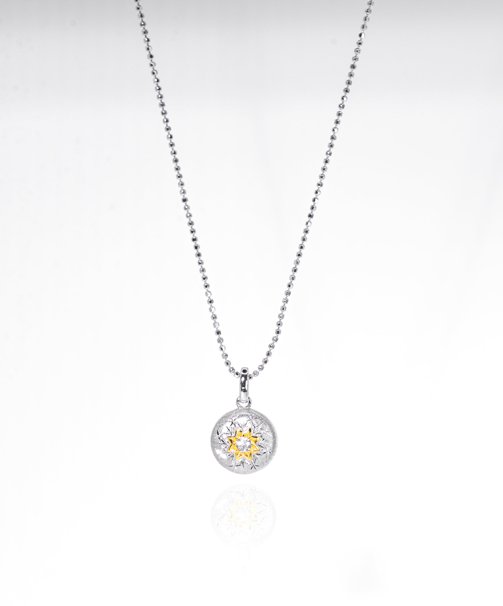 Silver necklace with a round pendant on a white background