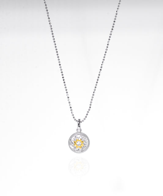 Silver necklace with a round pendant on a white background