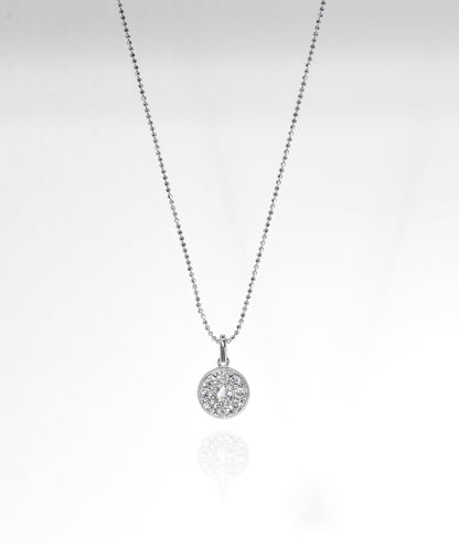 Silver necklace with a round pendant on a light gray background