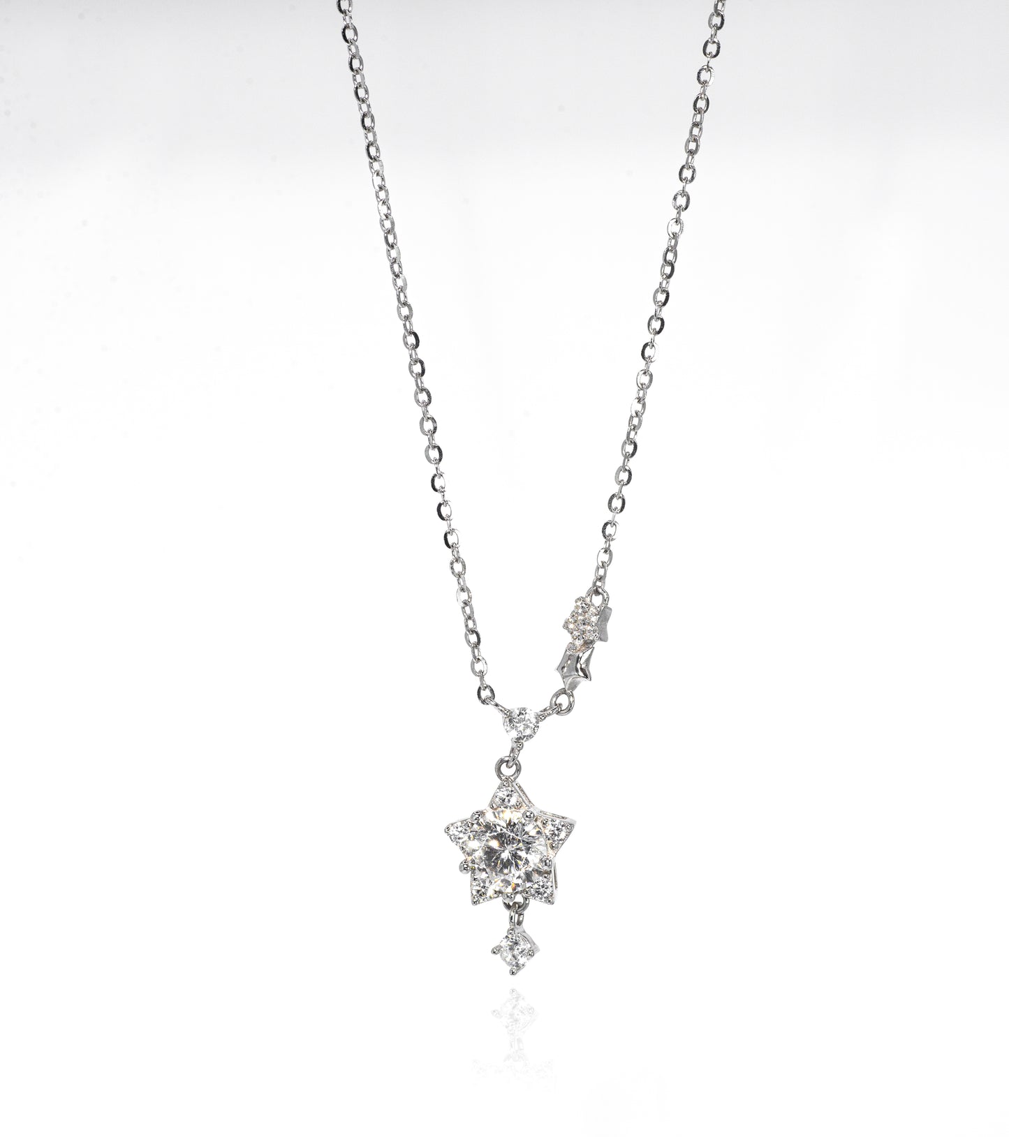 Silver necklace with a star-shaped pendant on a white background