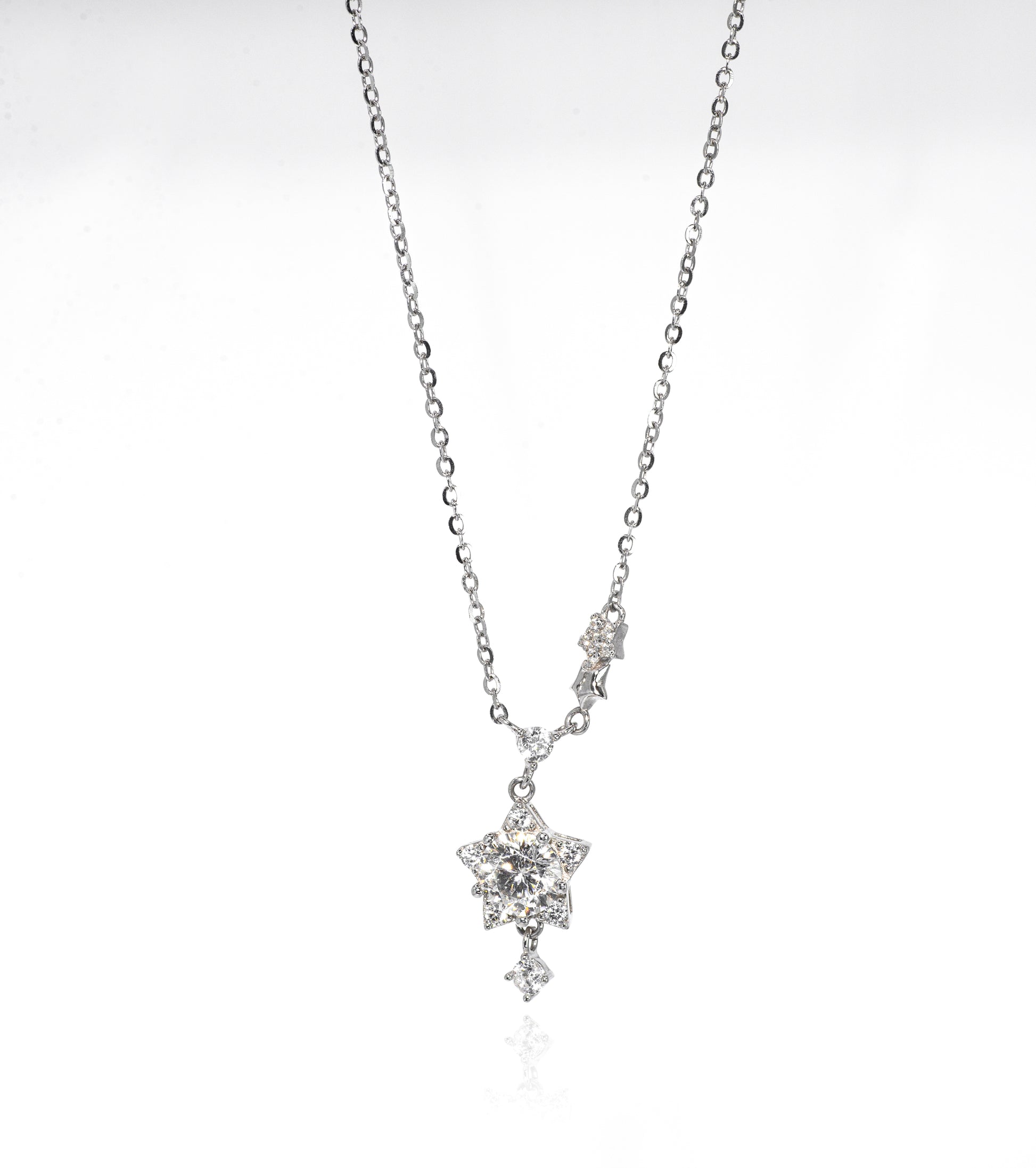 Silver necklace with a star-shaped pendant on a white background