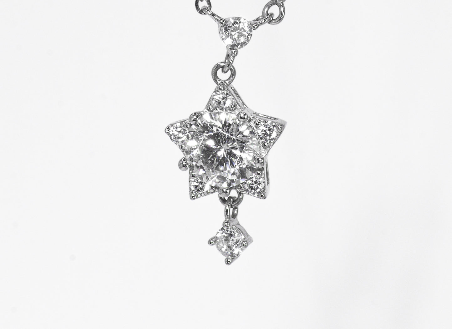 Star-shaped diamond pendant on a white background