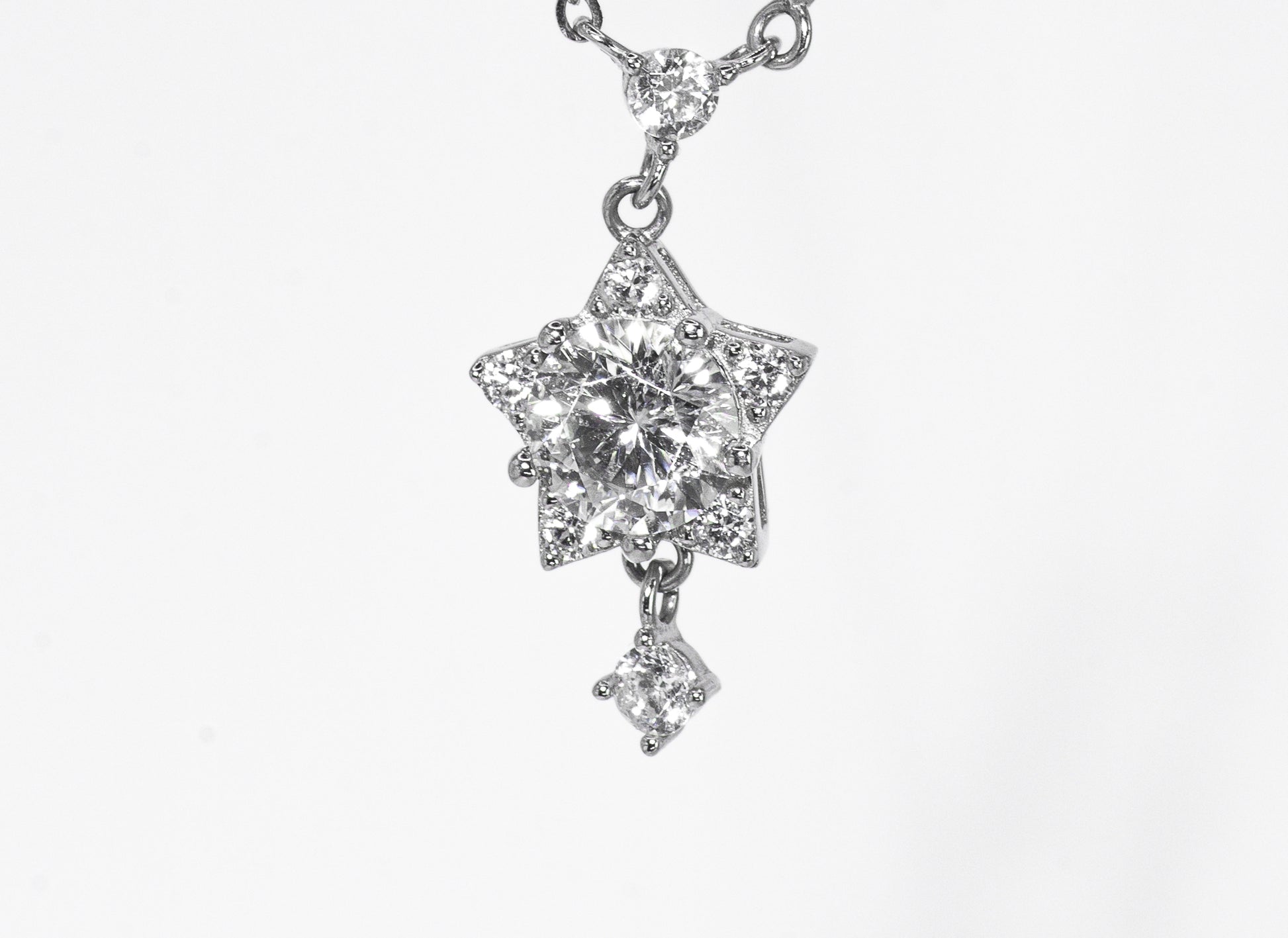 Star-shaped diamond pendant on a white background