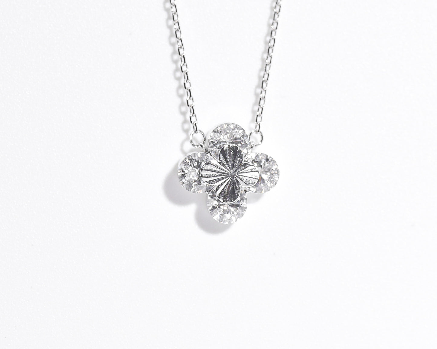 Silver necklace with a floral pendant on a white background