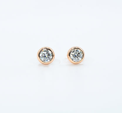 Pair of rose gold color with  Cubic Zirconia stud earrings on a white background