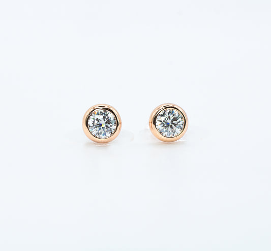 Pair of rose gold color with  Cubic Zirconia stud earrings on a white background