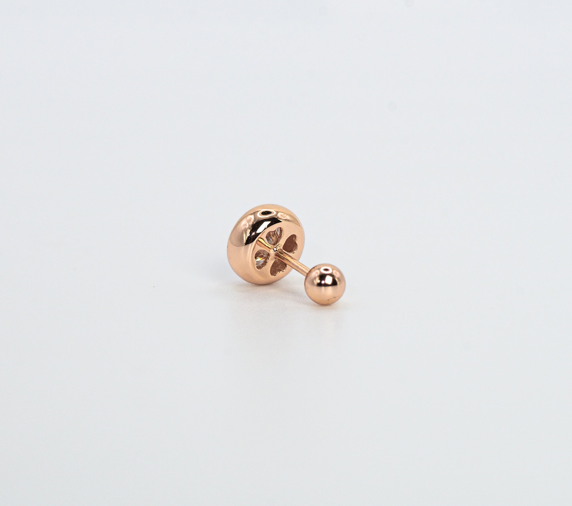 Rose gold color earring on a light gray background
