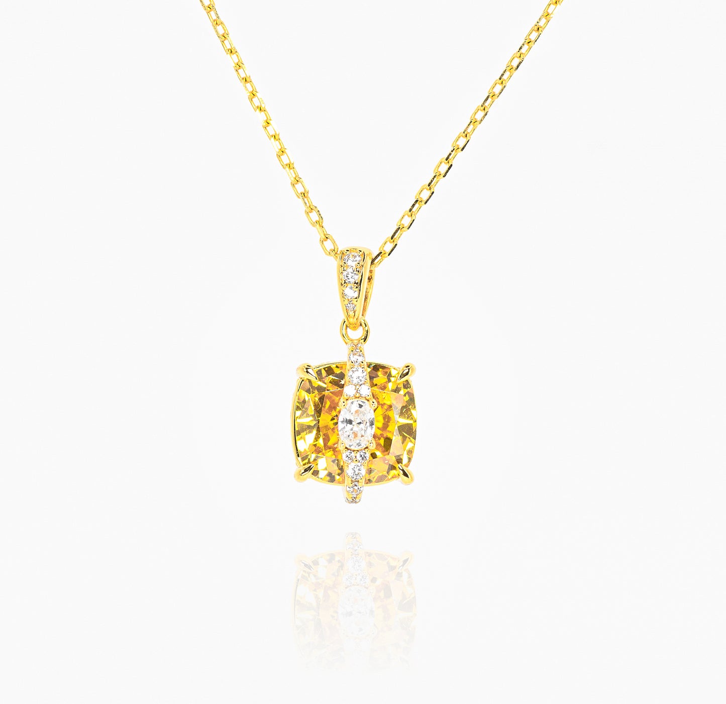 Gold color necklace with a yellow gemstone pendant on a white background