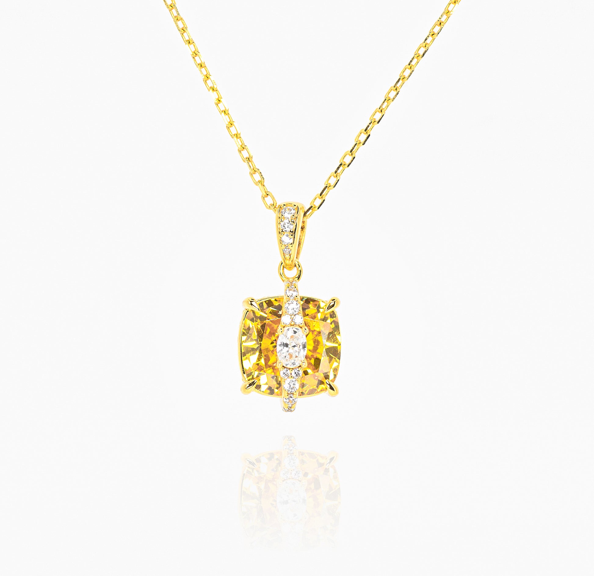 Gold color necklace with a yellow gemstone pendant on a white background