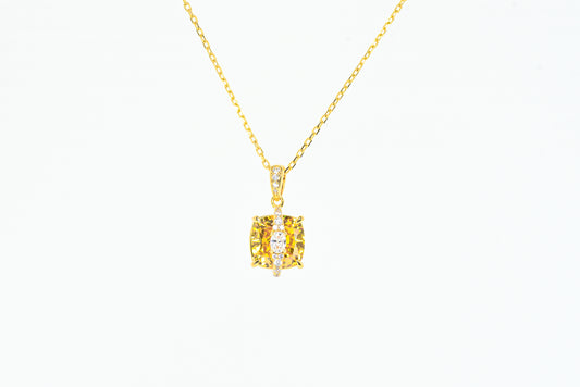 Gold color necklace with a yellow gemstone pendant on a white background